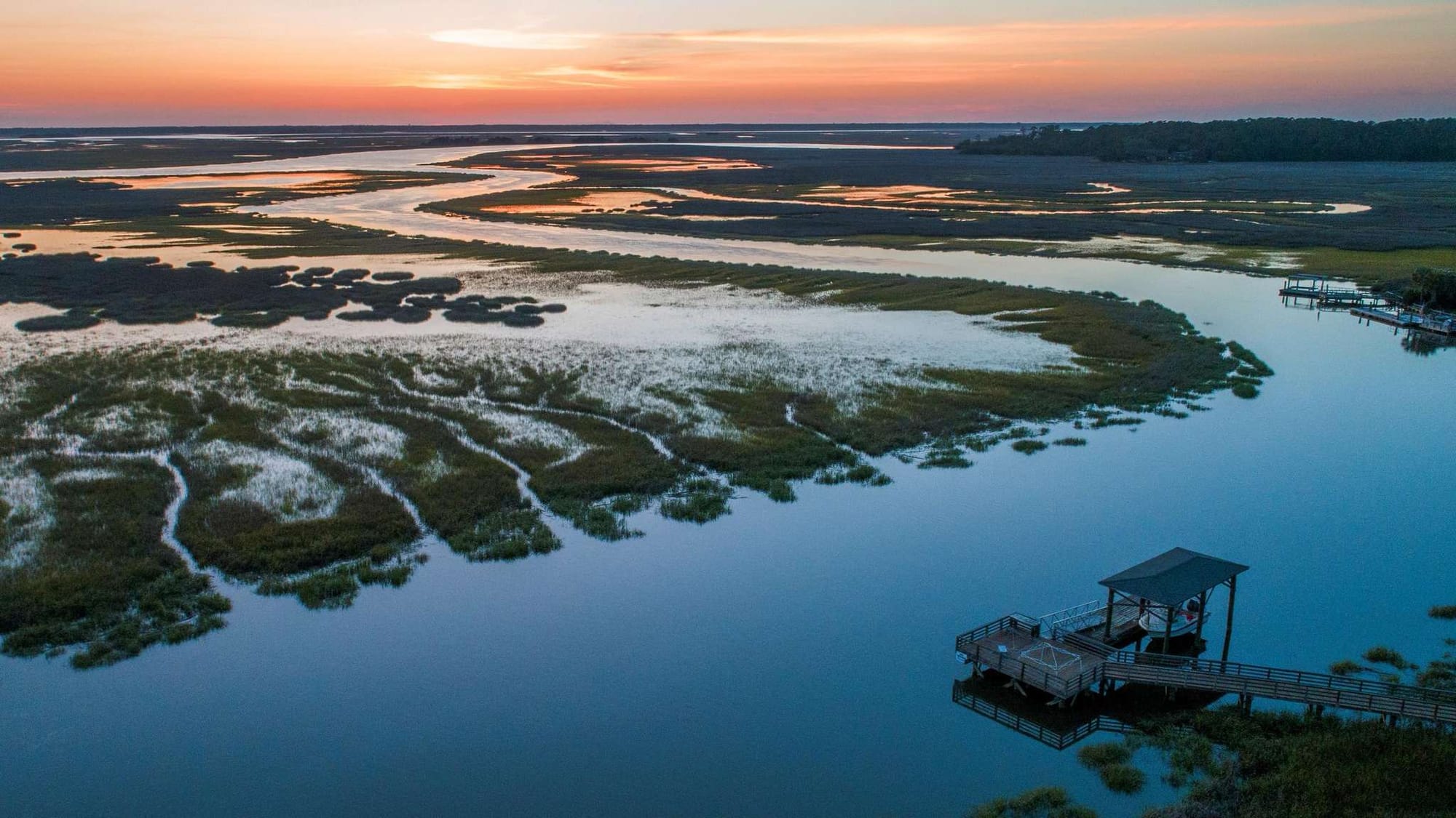 Sunset over marshland and dock.
