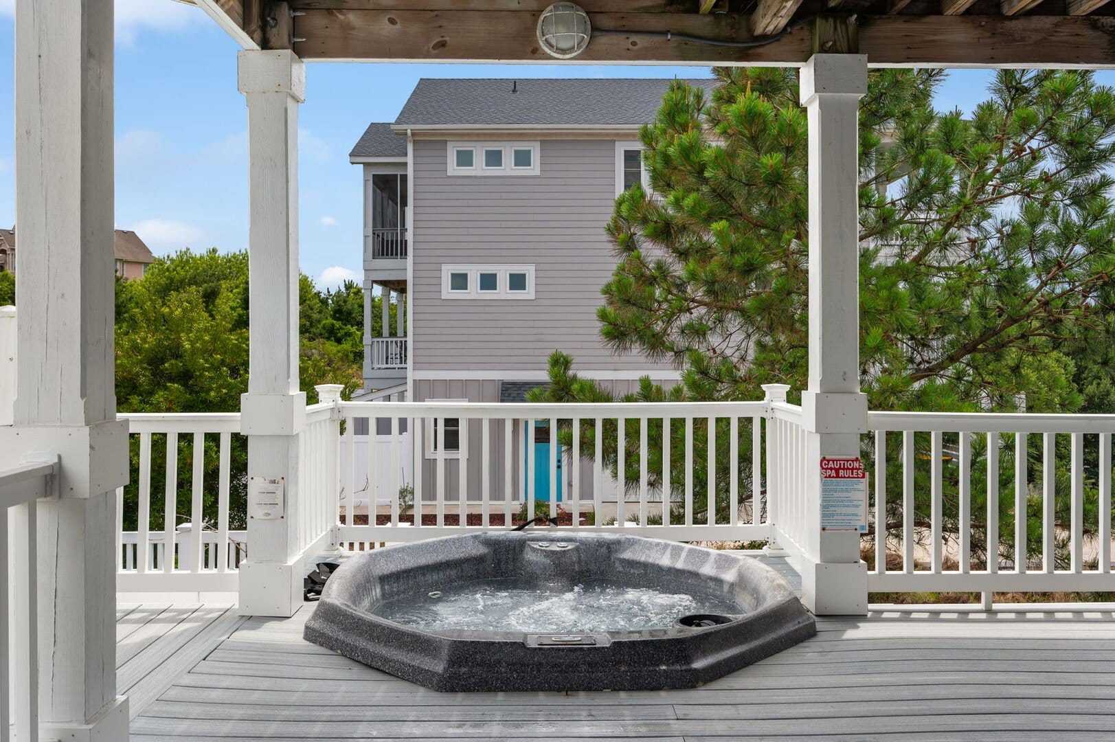 Hot tub on wooden deck outdoors.