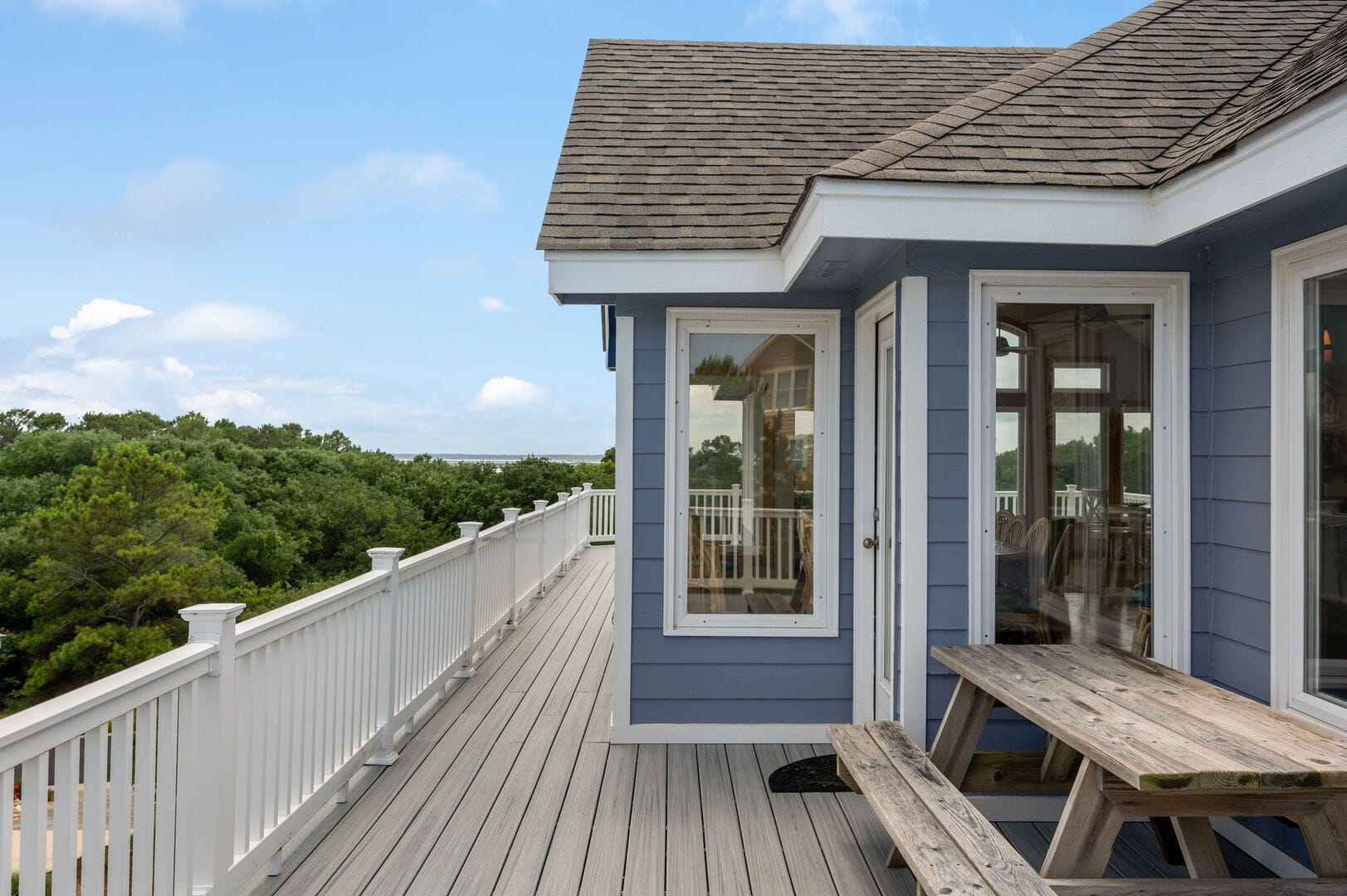 Blue house with wooden deck.