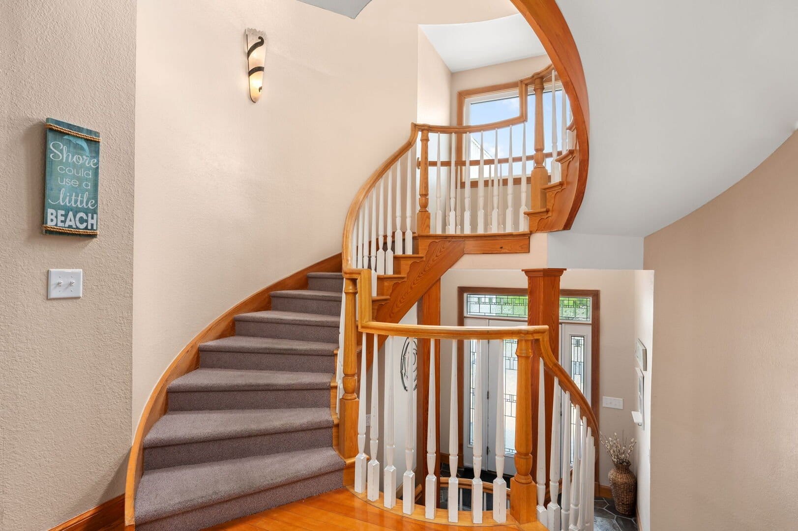 Wooden spiral staircase with carpeted steps.
