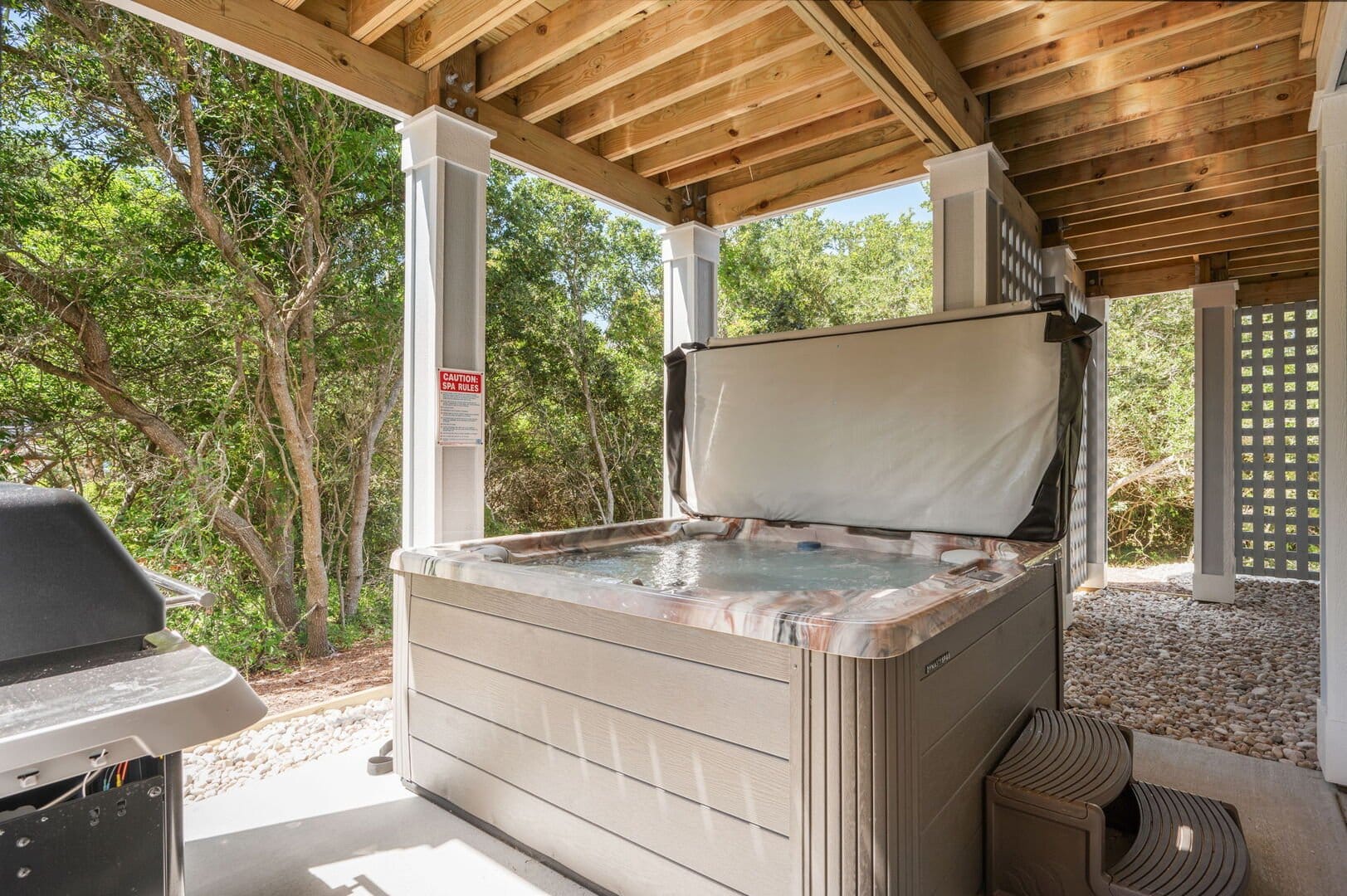 Outdoor hot tub under wooden patio.