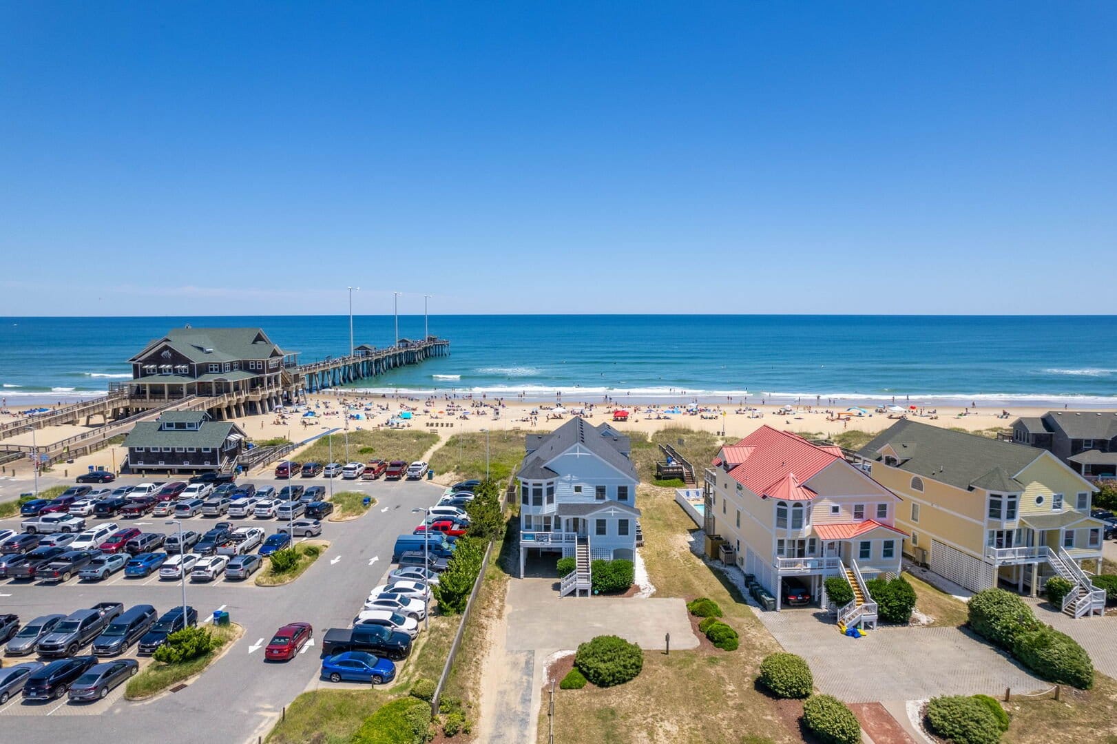 Beachfront houses, pier, and parking.
