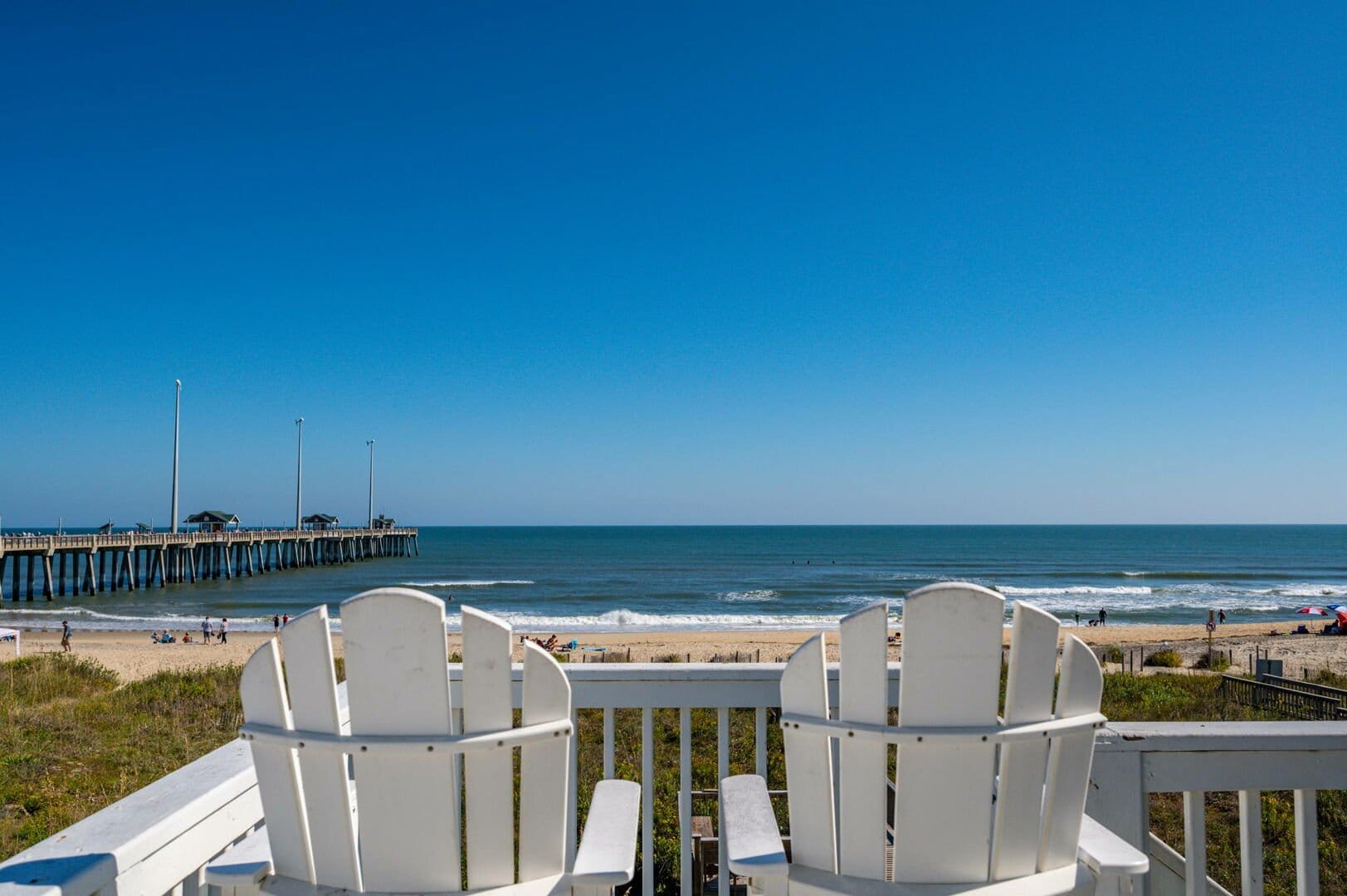 Chairs overlooking beach and pier.