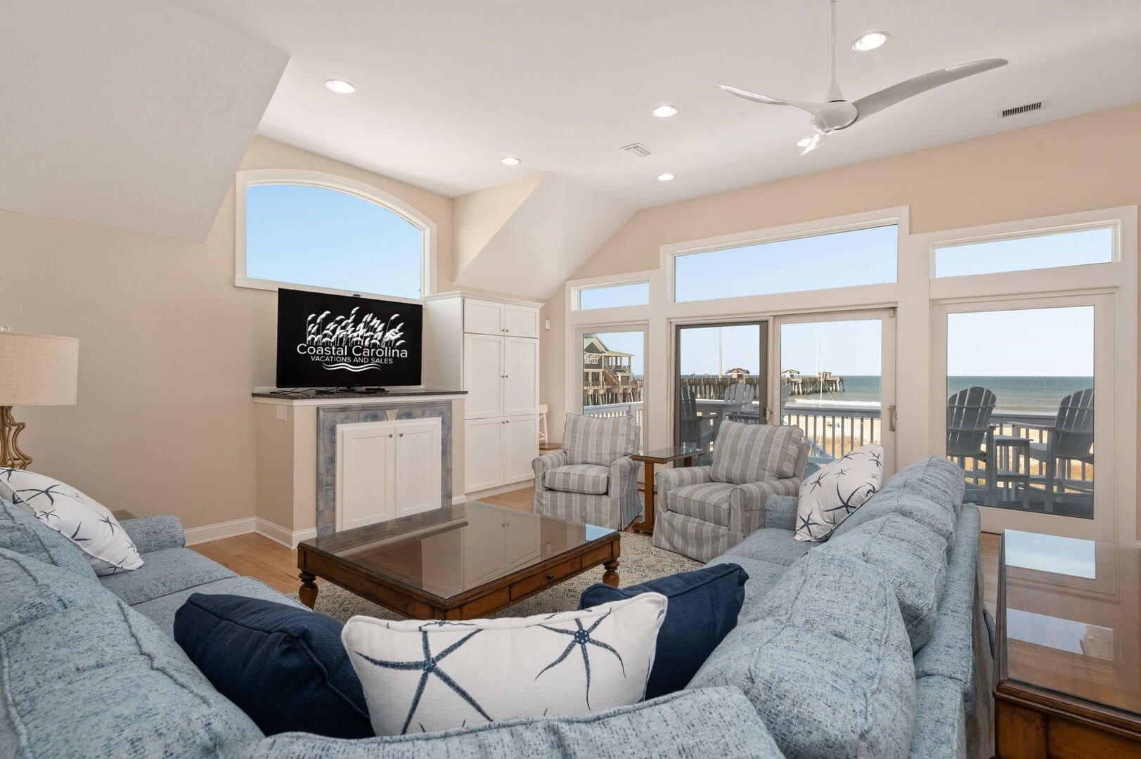 Beachfront living room, large windows.