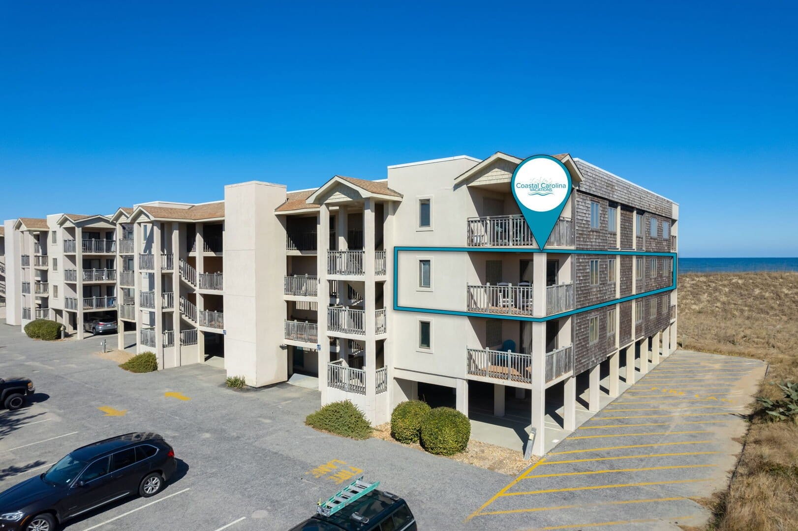 Beachfront apartment building with parking.