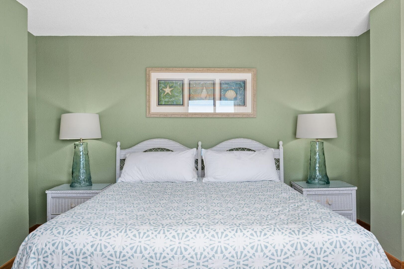 Bed with green walls, lamps.