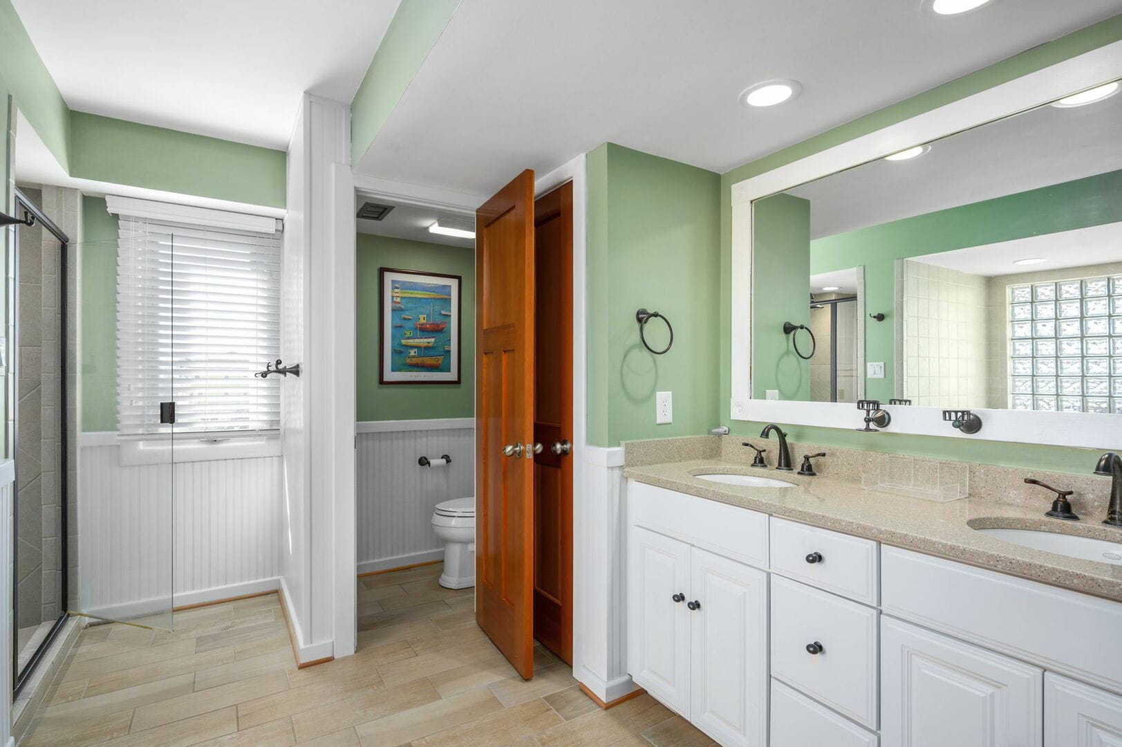 Green bathroom with dual sinks.
