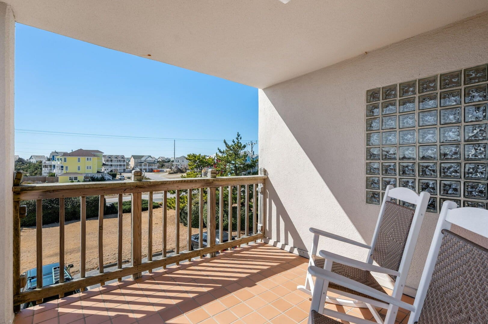 Balcony with chairs, distant houses.