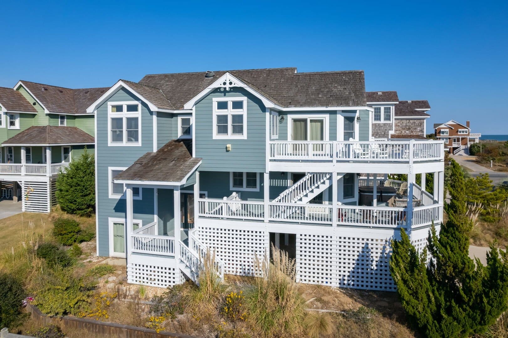 Blue coastal house with wraparound porch.