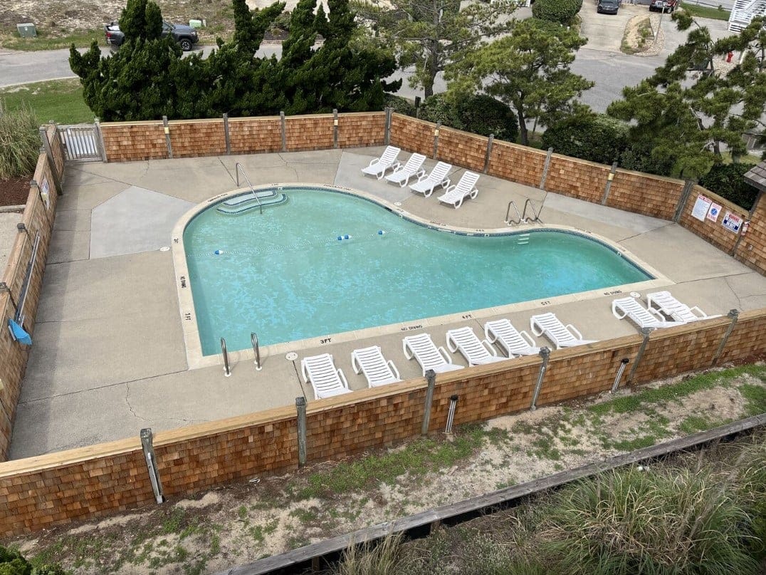 Outdoor pool with empty loungers.