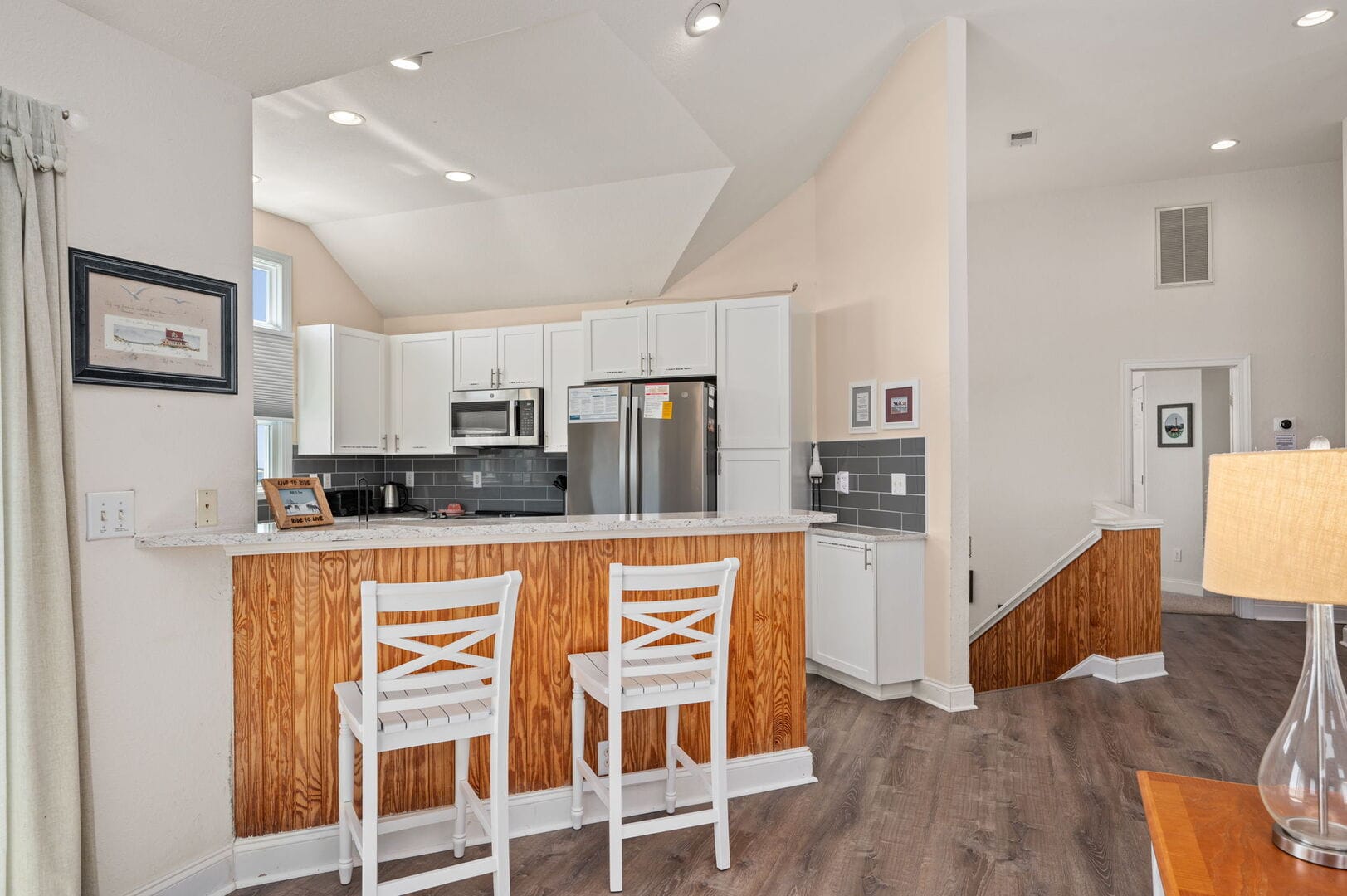 Kitchen with bar stools and appliances.