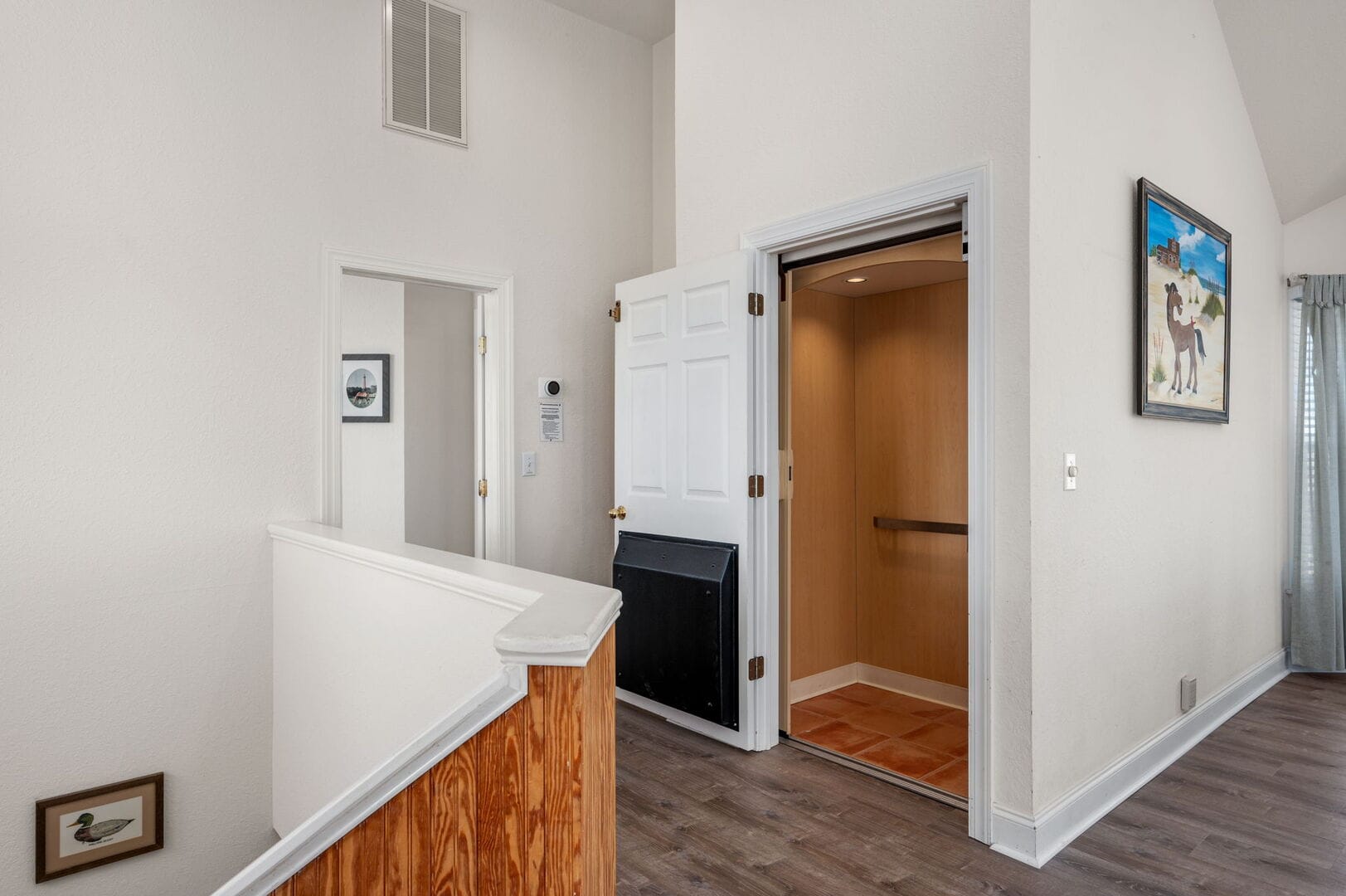 Elevator in residential hallway, paintings.