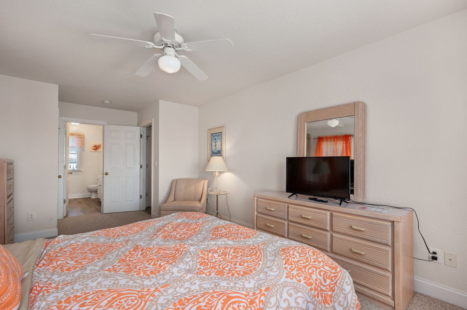 Bedroom with mirror, TV, bed.