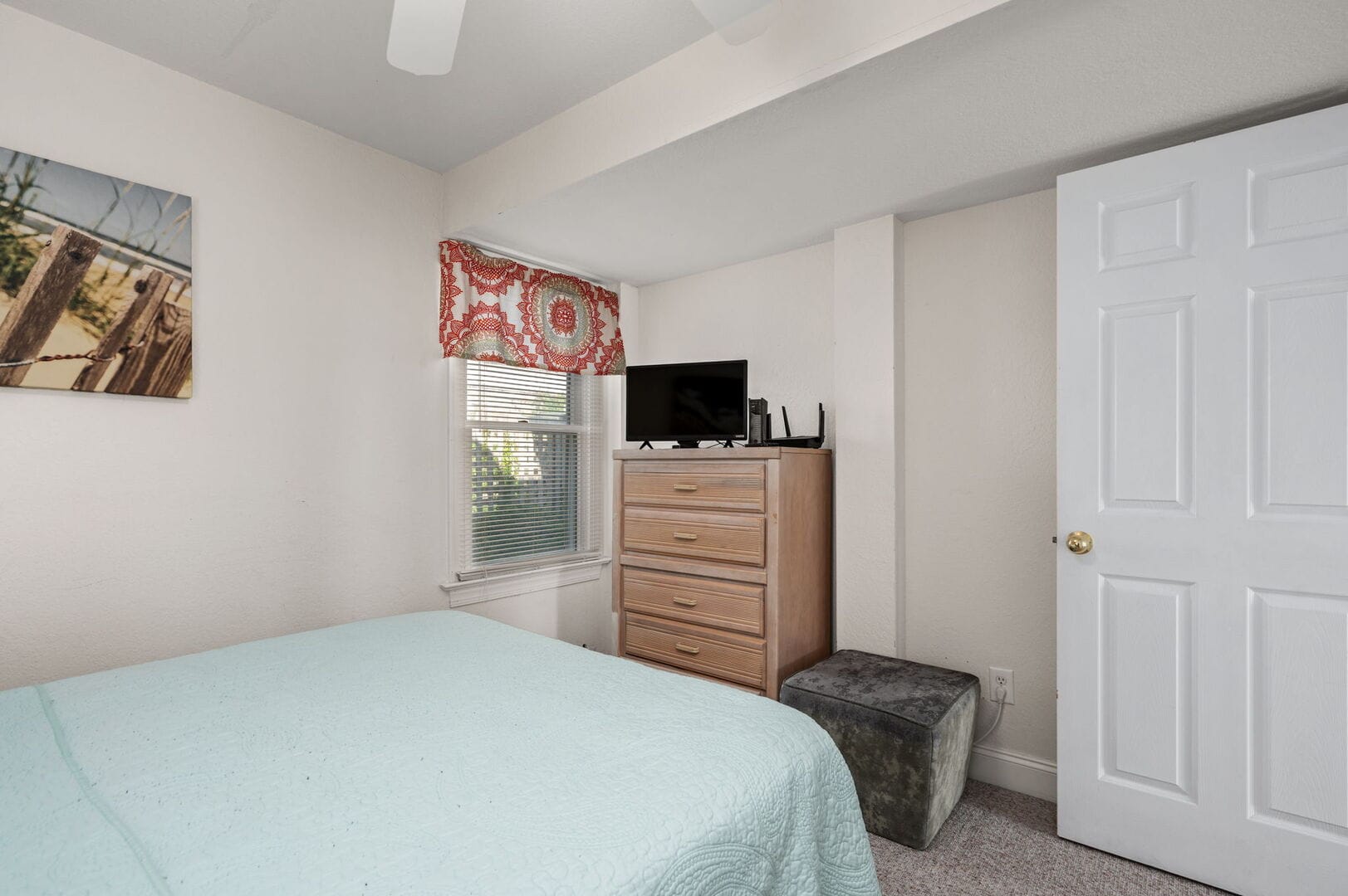 Bedroom with dresser and window.