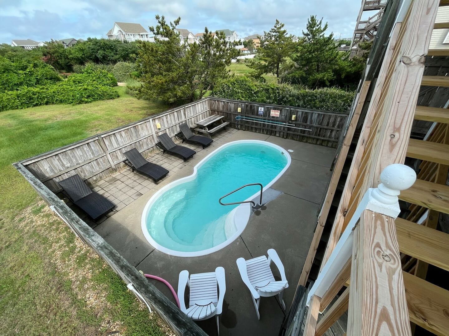Backyard pool with lounge chairs.