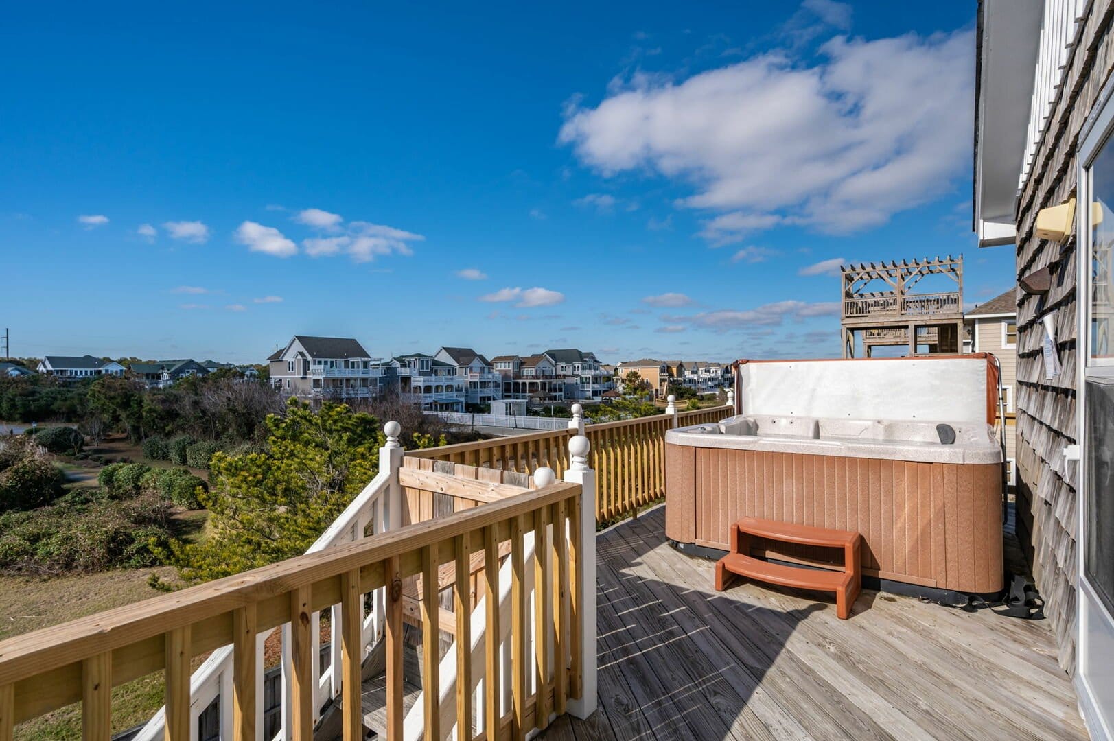 Deck with hot tub, houses view.
