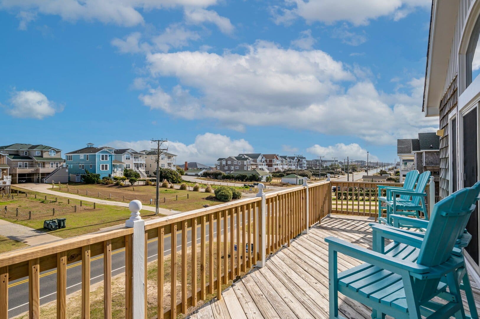 Blue chairs on a beach balcony.