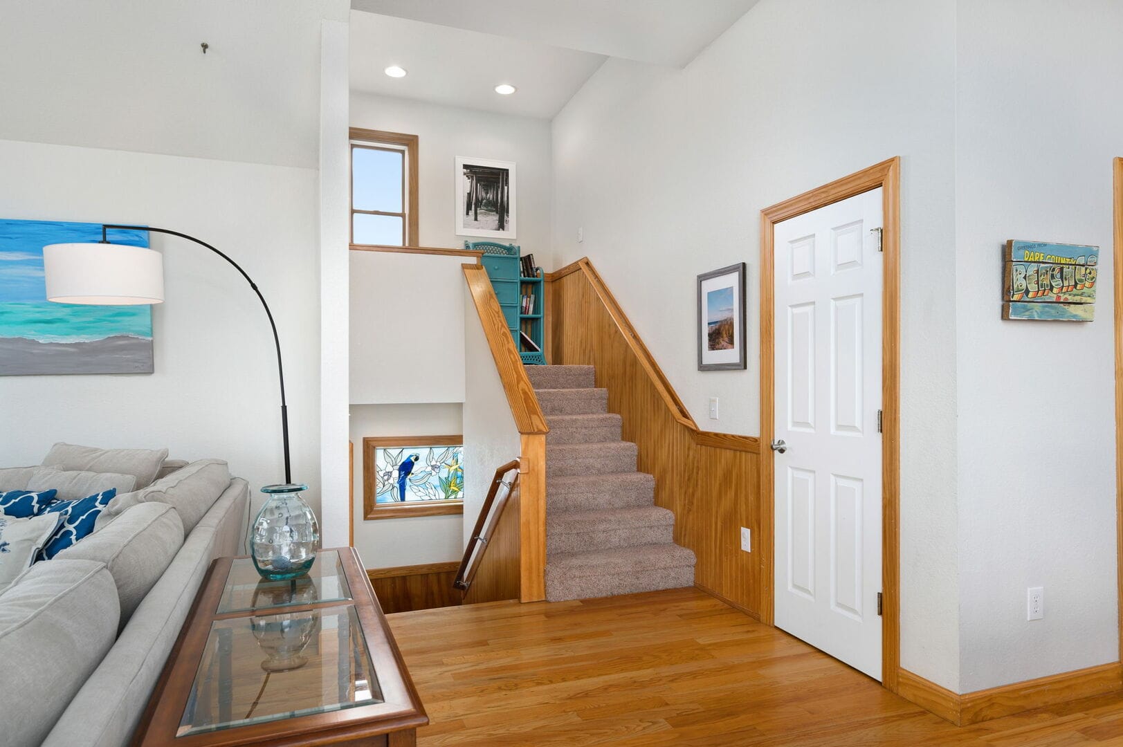 Living room with stairs and artwork.