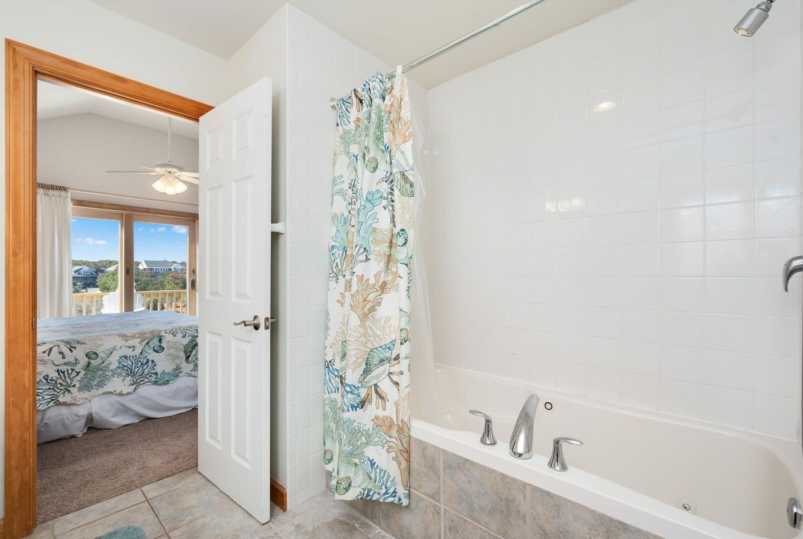 Bathroom with tub and bedroom view.