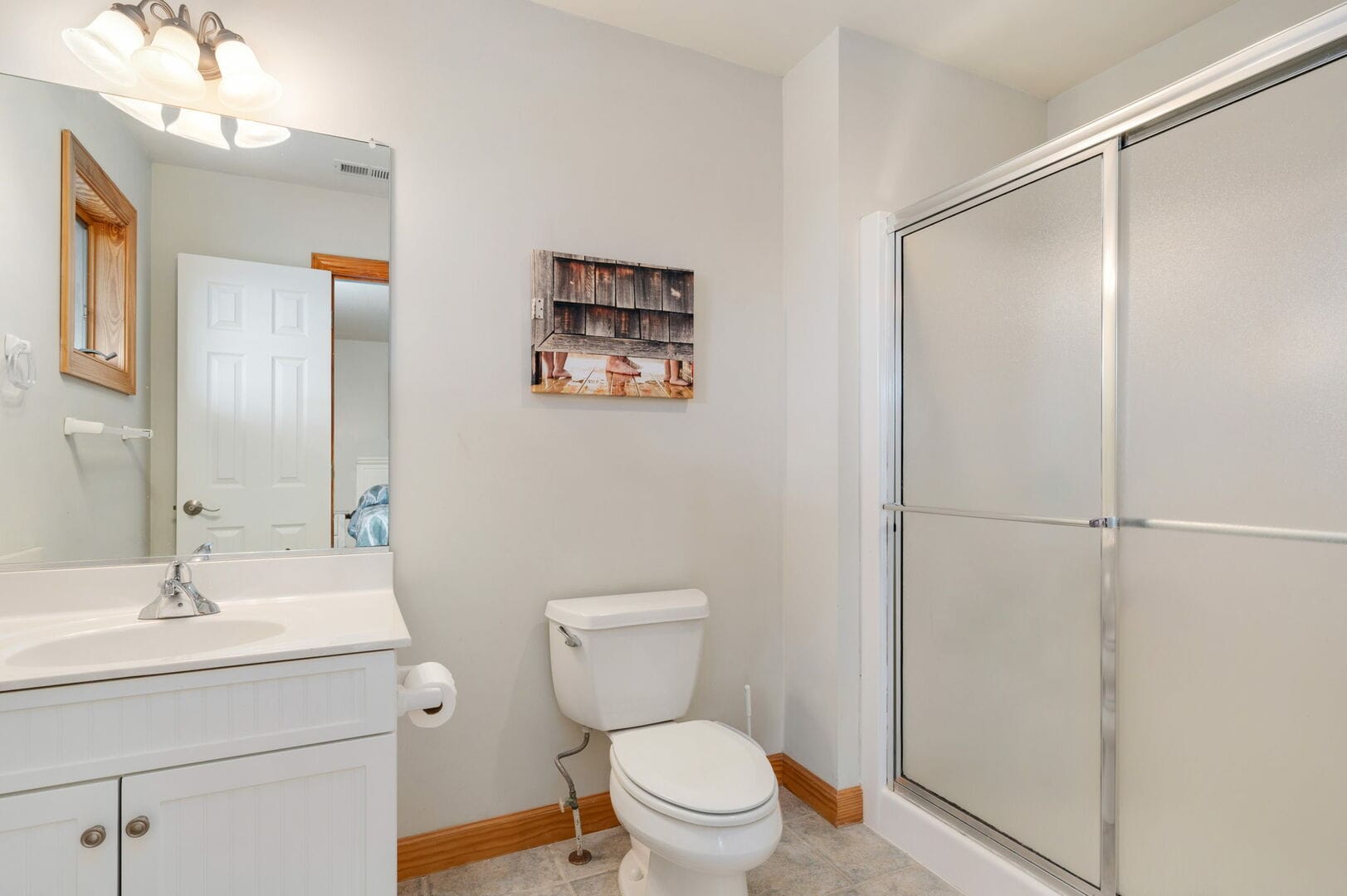 White bathroom with shower and toilet.