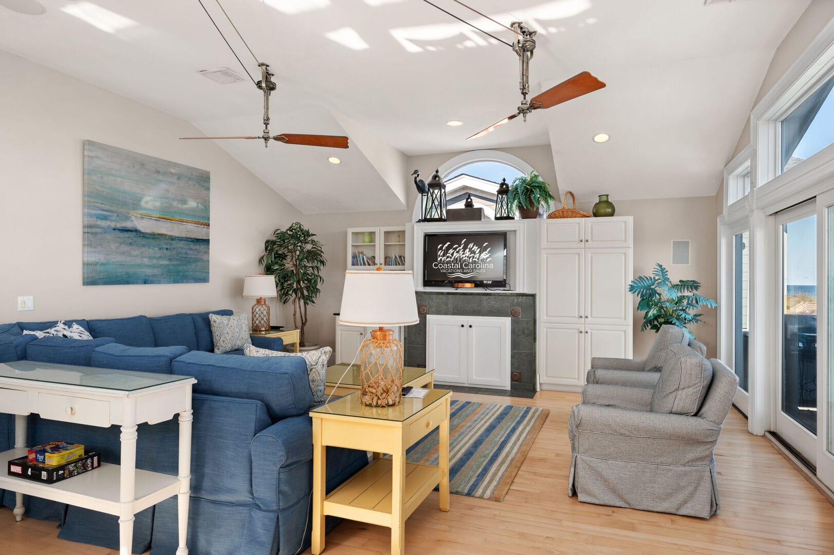 Coastal-themed living room, large windows.