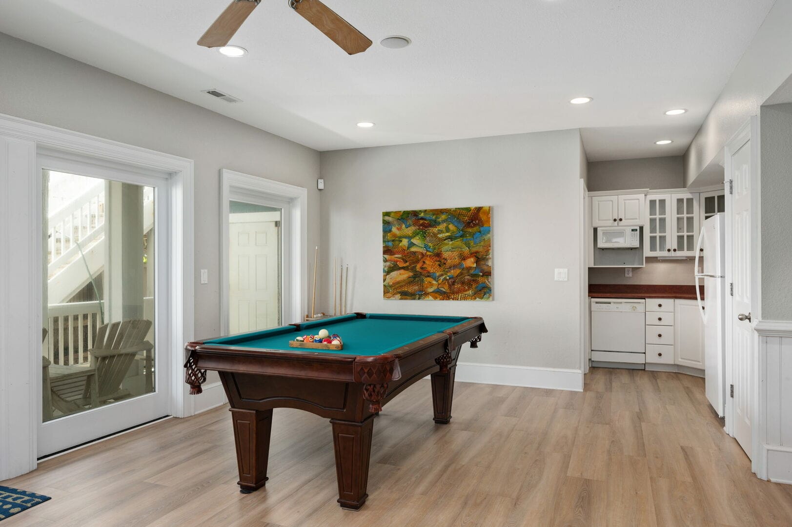 Room with pool table, kitchen.