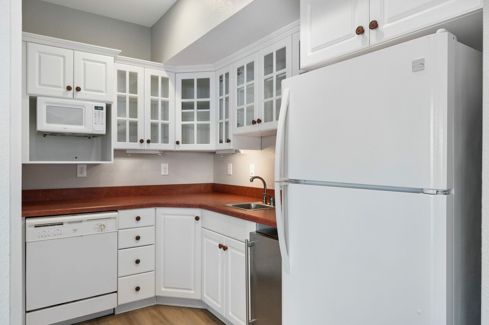 Compact kitchen with white cabinets.