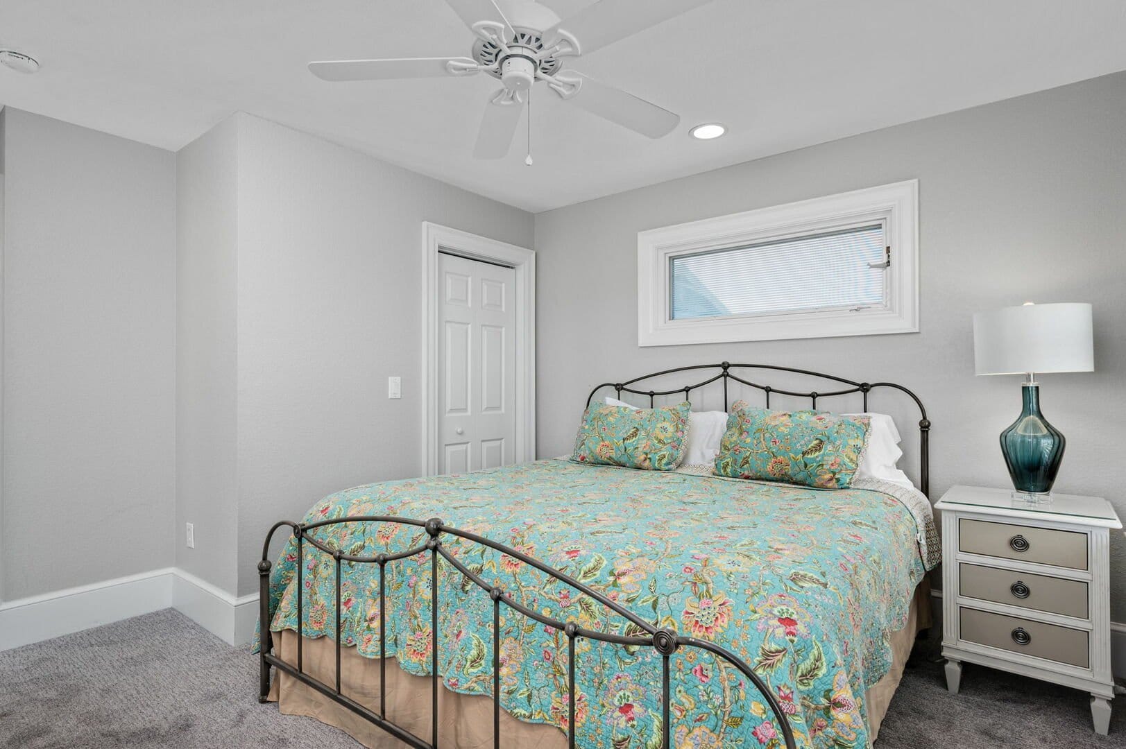 Bedroom with floral quilt bed.