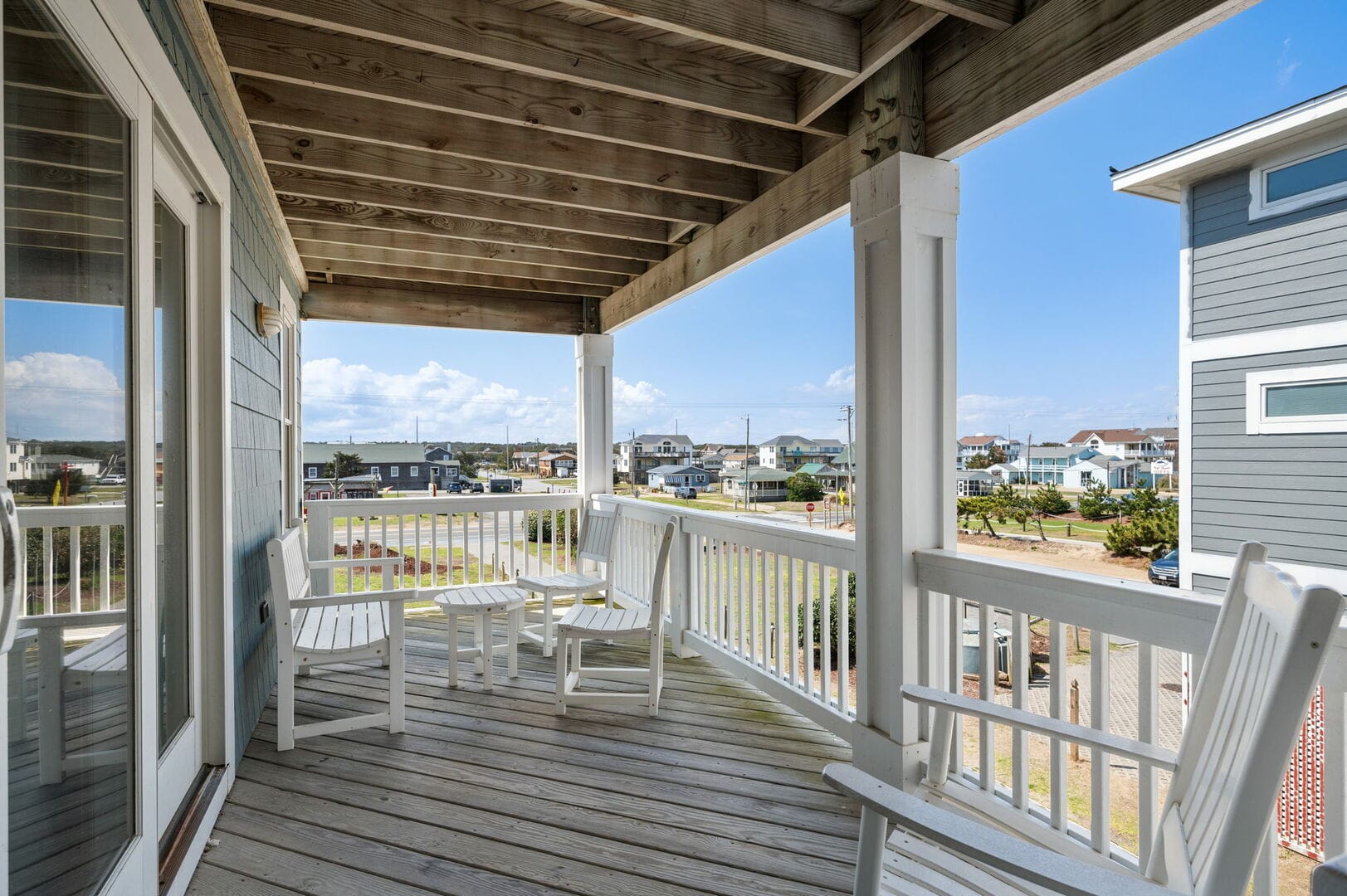 Covered porch with white chairs, view.