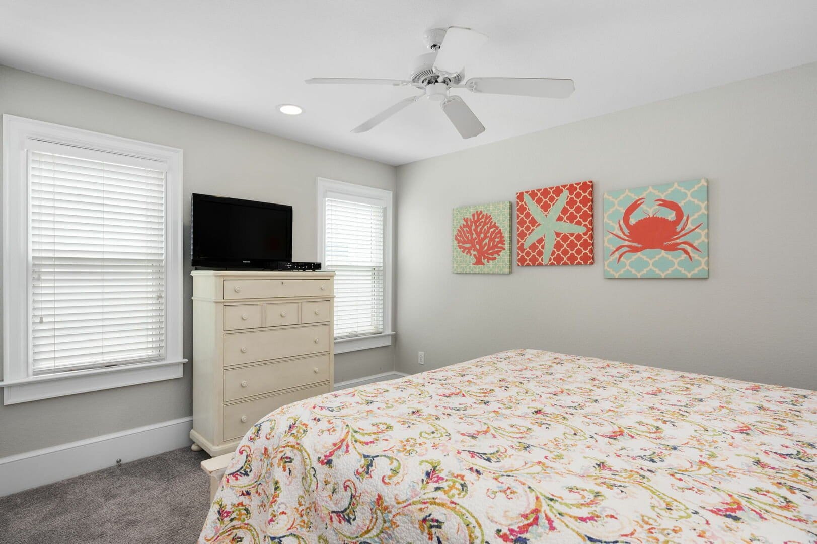 Coastal-themed bedroom with ceiling fan.