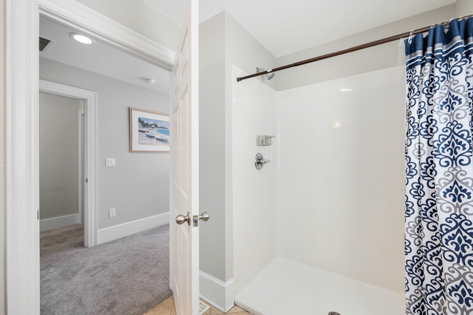 Bathroom with blue patterned curtain.