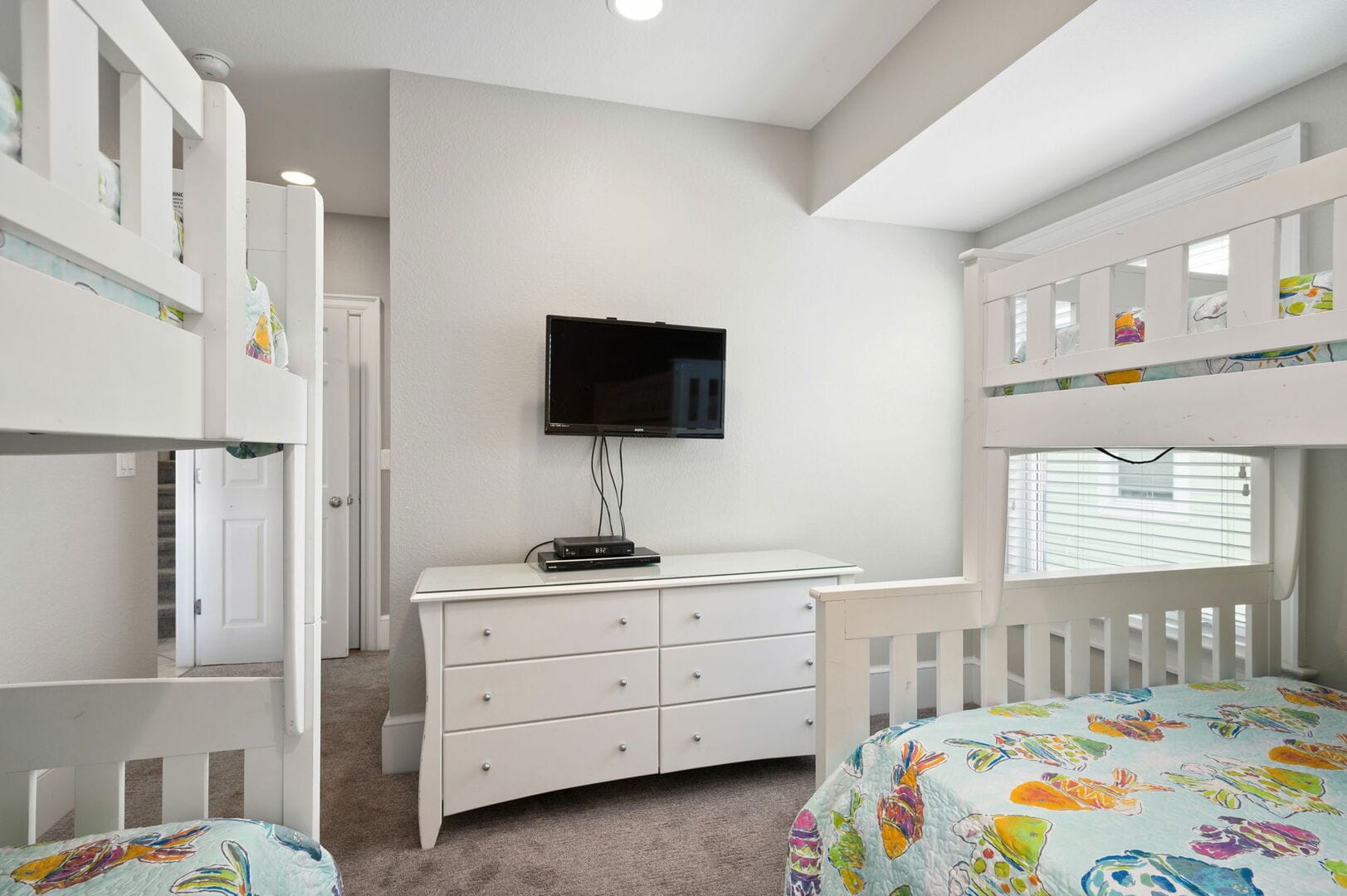 Bedroom with bunk beds, dresser, TV.