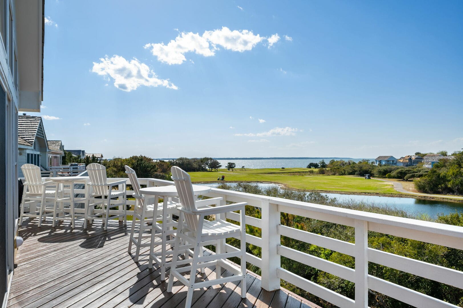 Deck overlooking golf course and water.