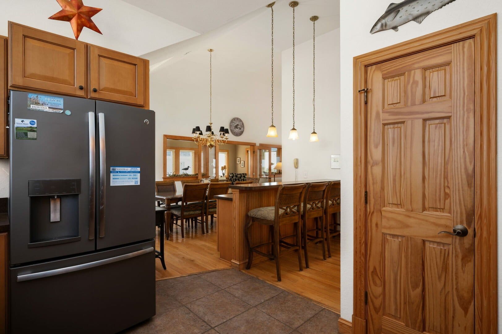 Kitchen with bar stools and fridge.