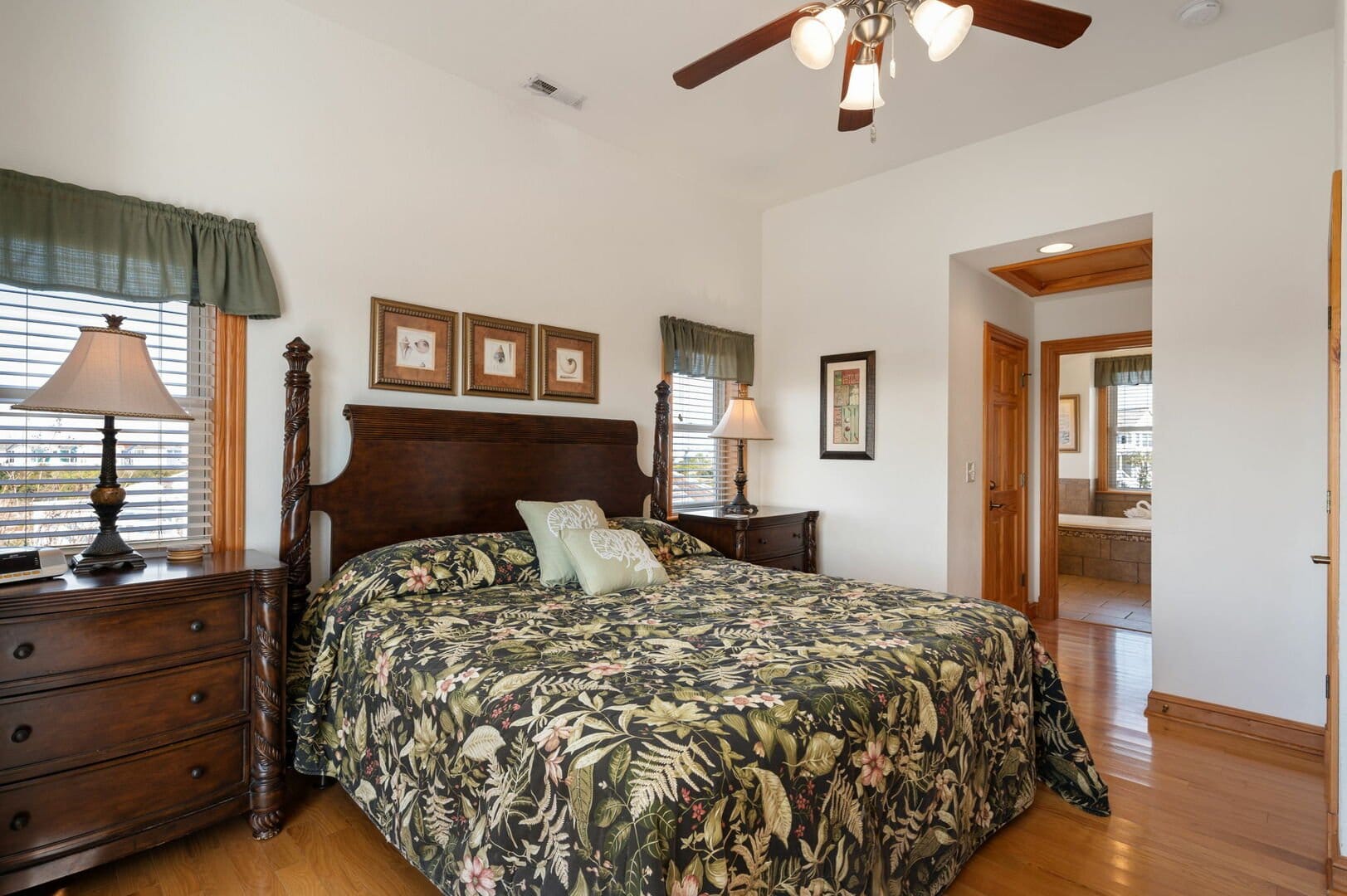 Bedroom with floral bedspread, lamps.