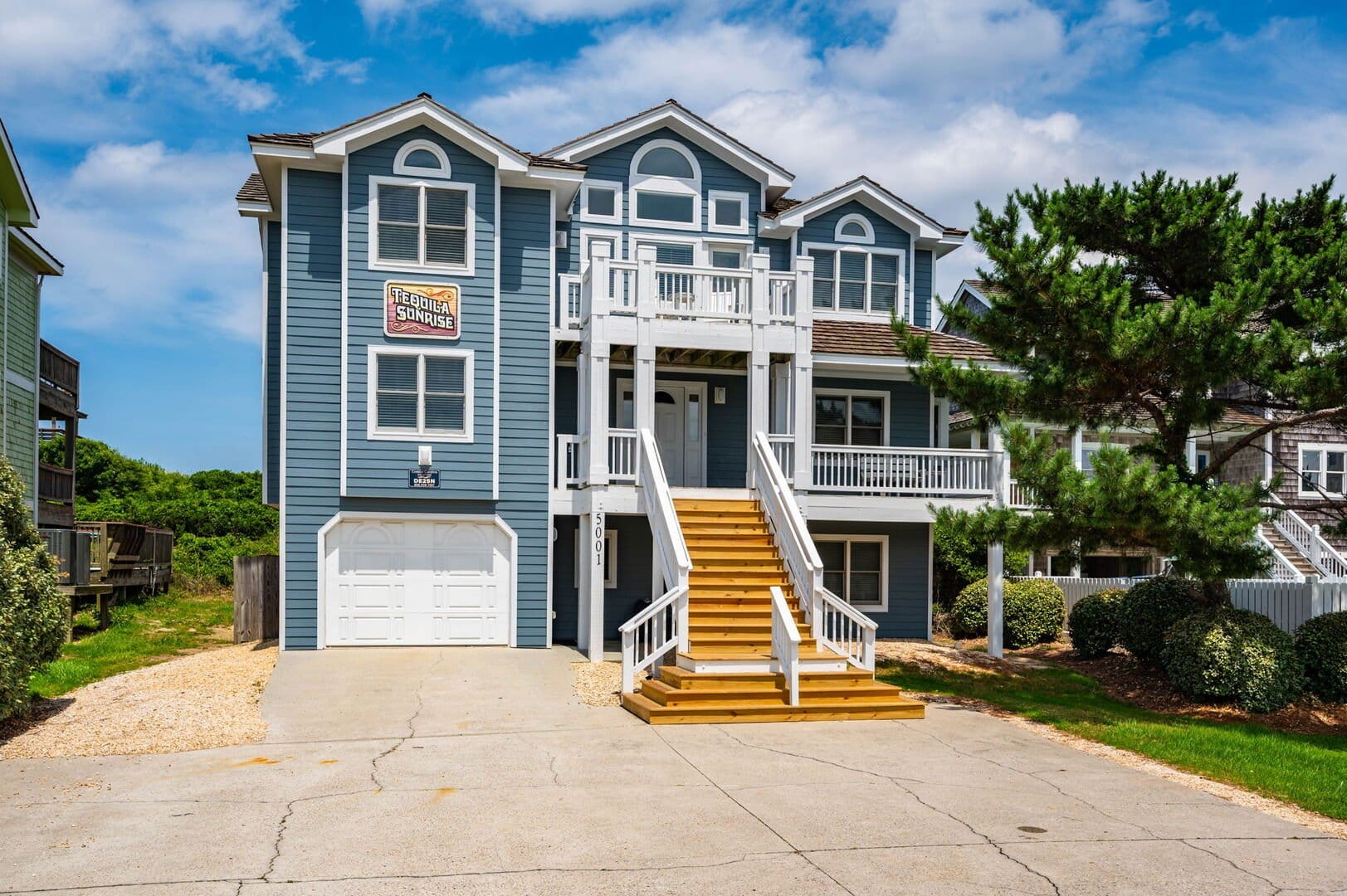 Large blue house with stairs.