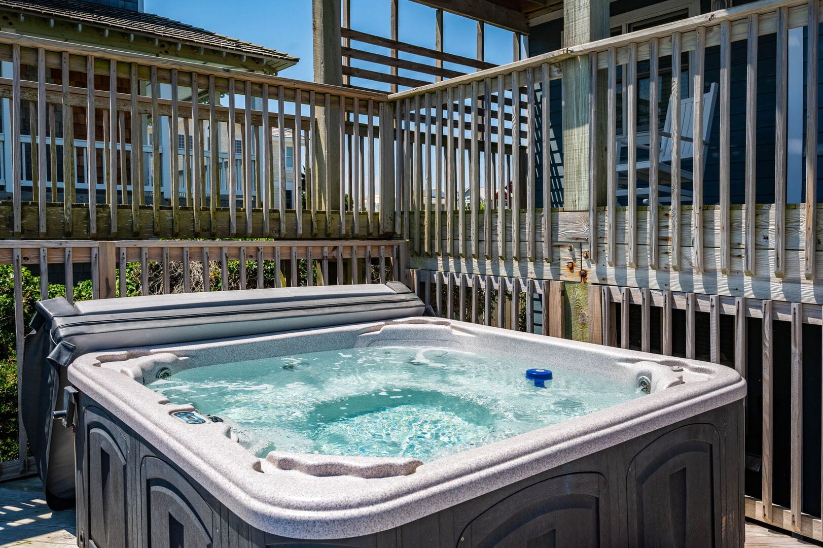 Outdoor hot tub on wooden deck.