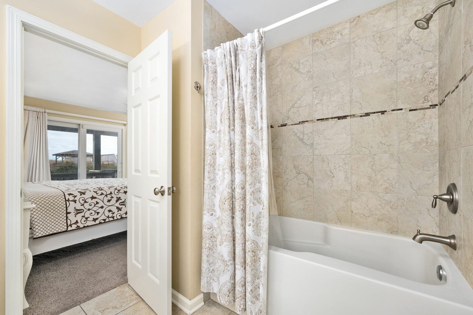 Bathroom with tub and bedroom.