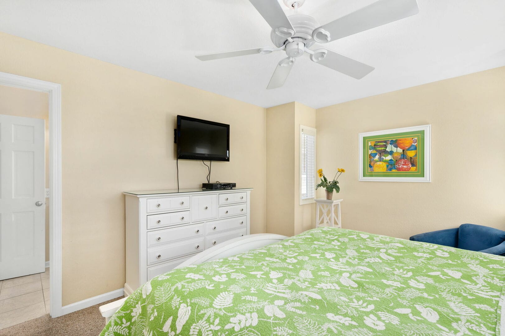 Bedroom with green patterned bedspread.