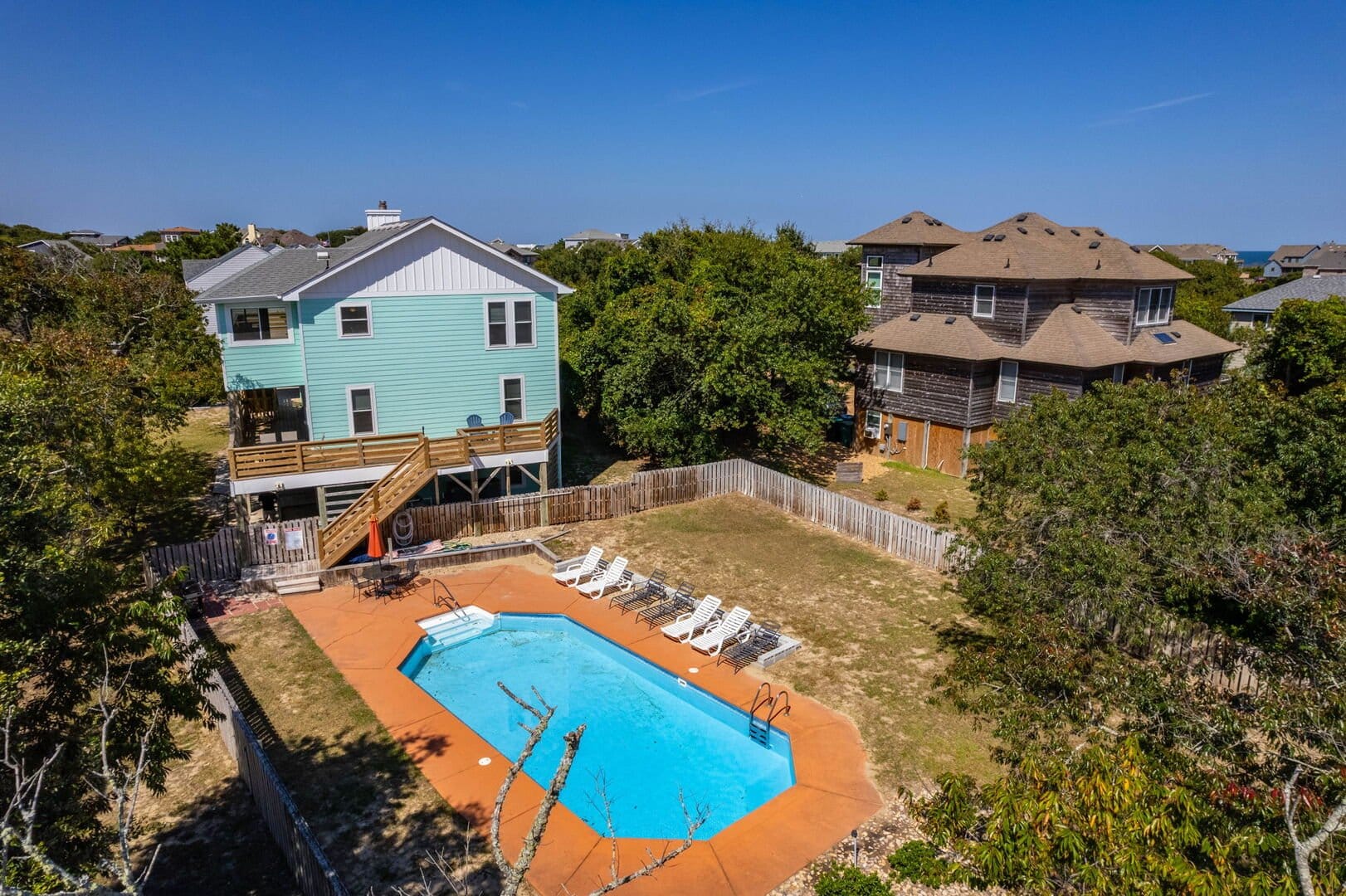 Backyard pool with surrounding houses.