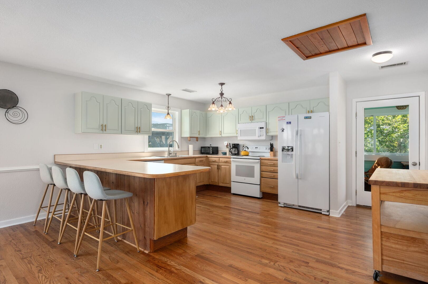 Spacious kitchen with wooden flooring.