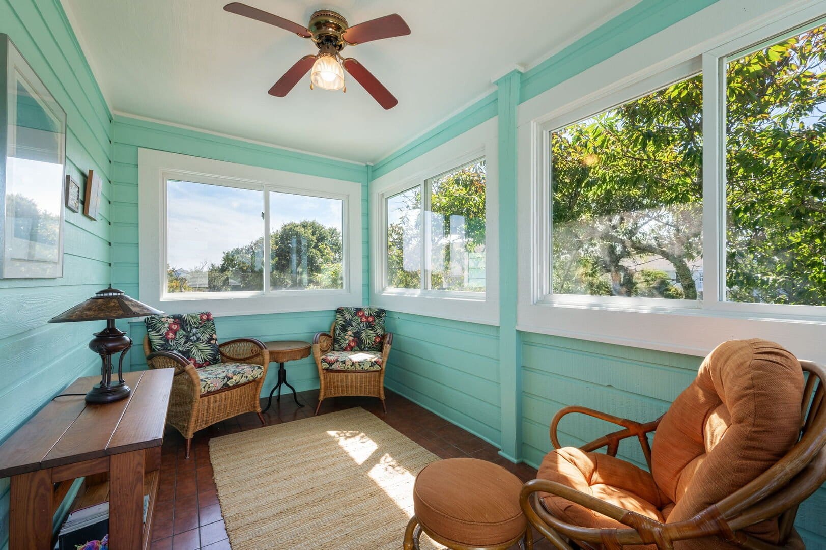 Bright sunroom with wicker furniture.