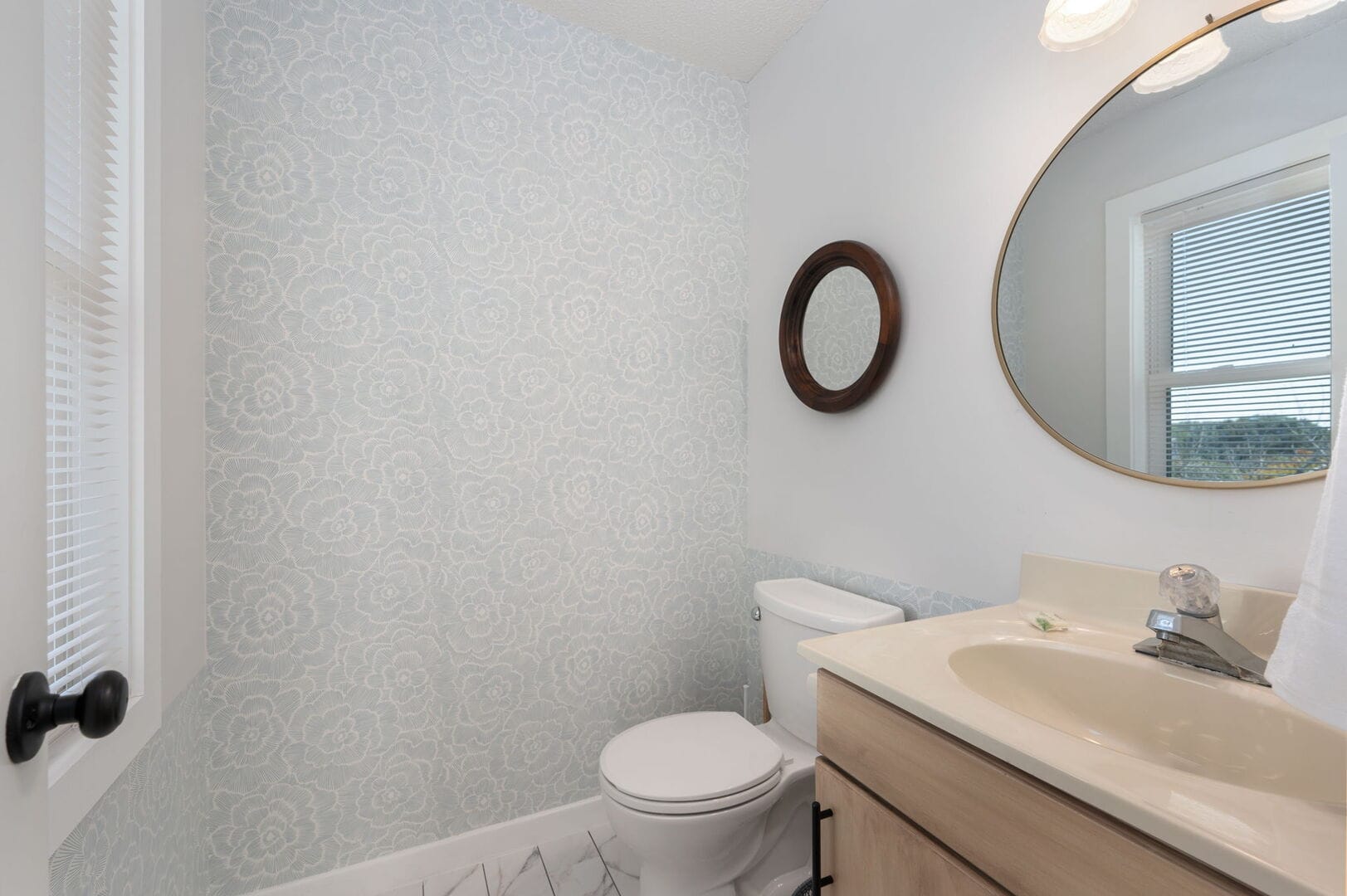 Small bathroom with floral wallpaper.