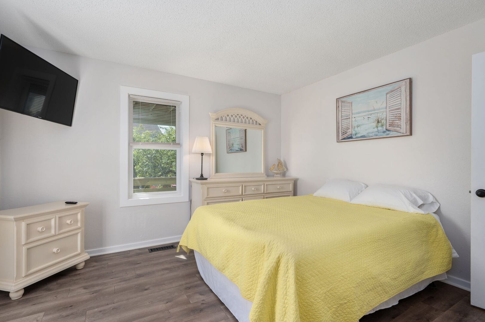 Bedroom with yellow bedding, window.