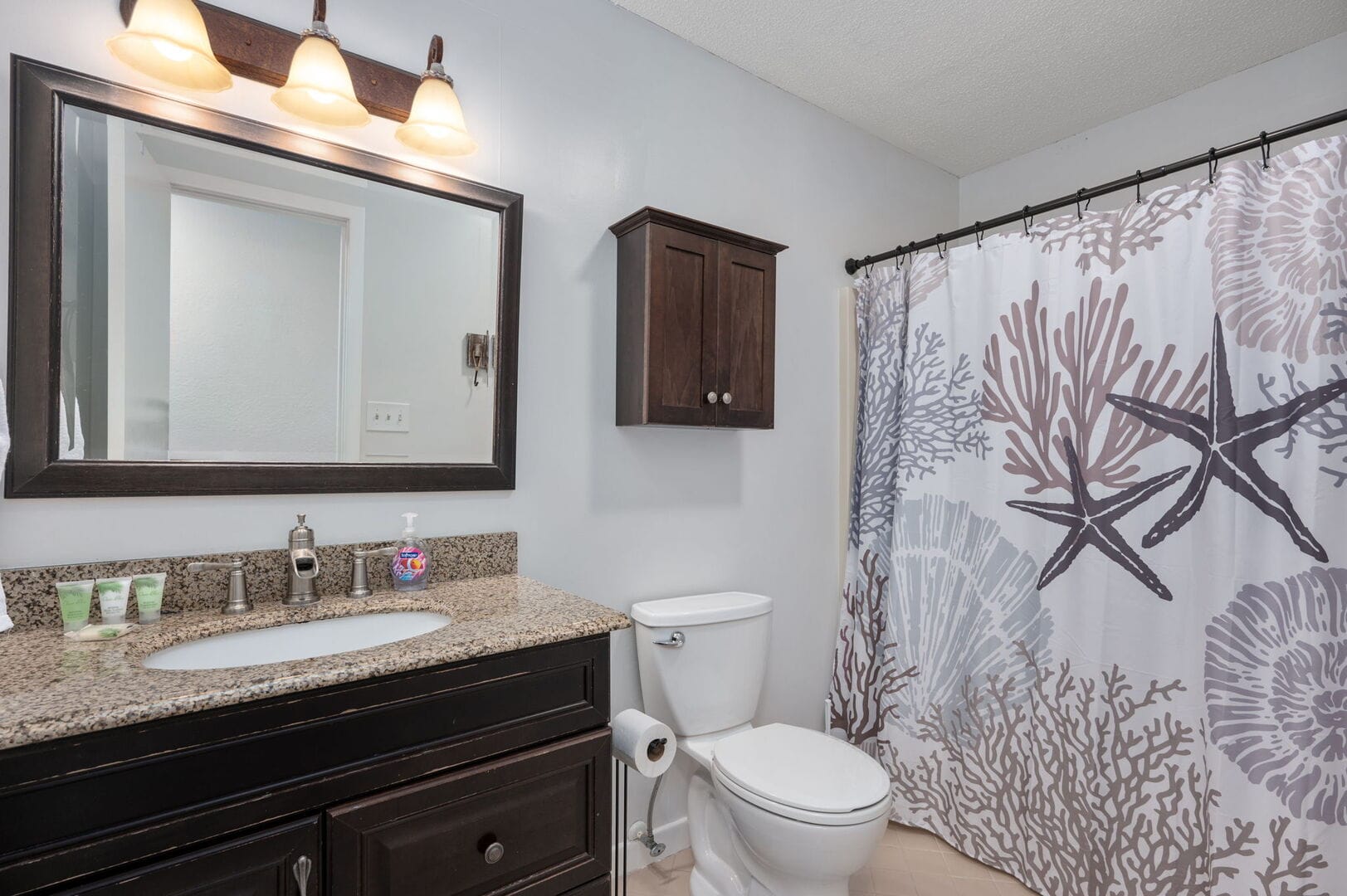 Bathroom with ocean-themed shower curtain.