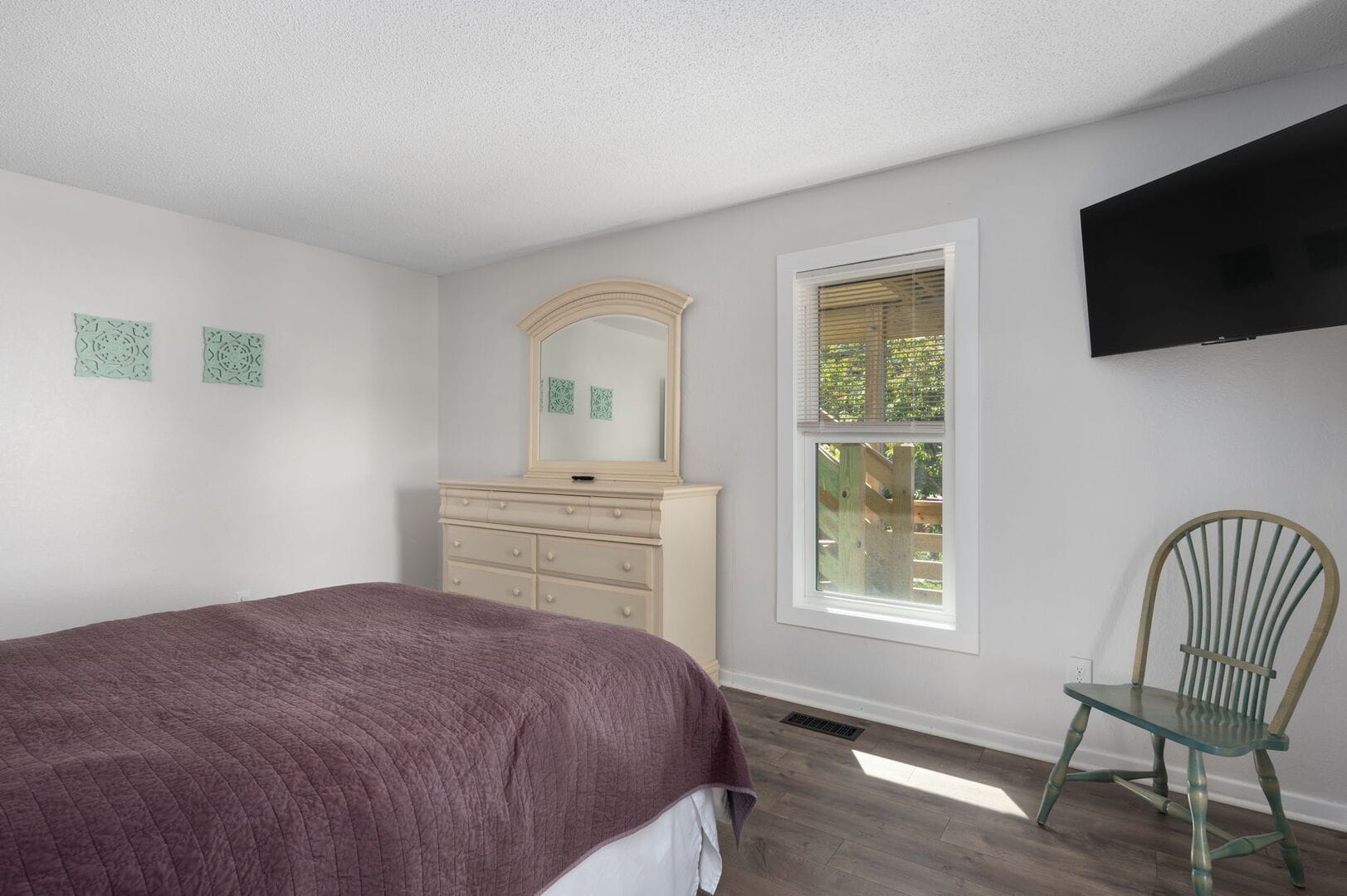 Bedroom with dresser and window.