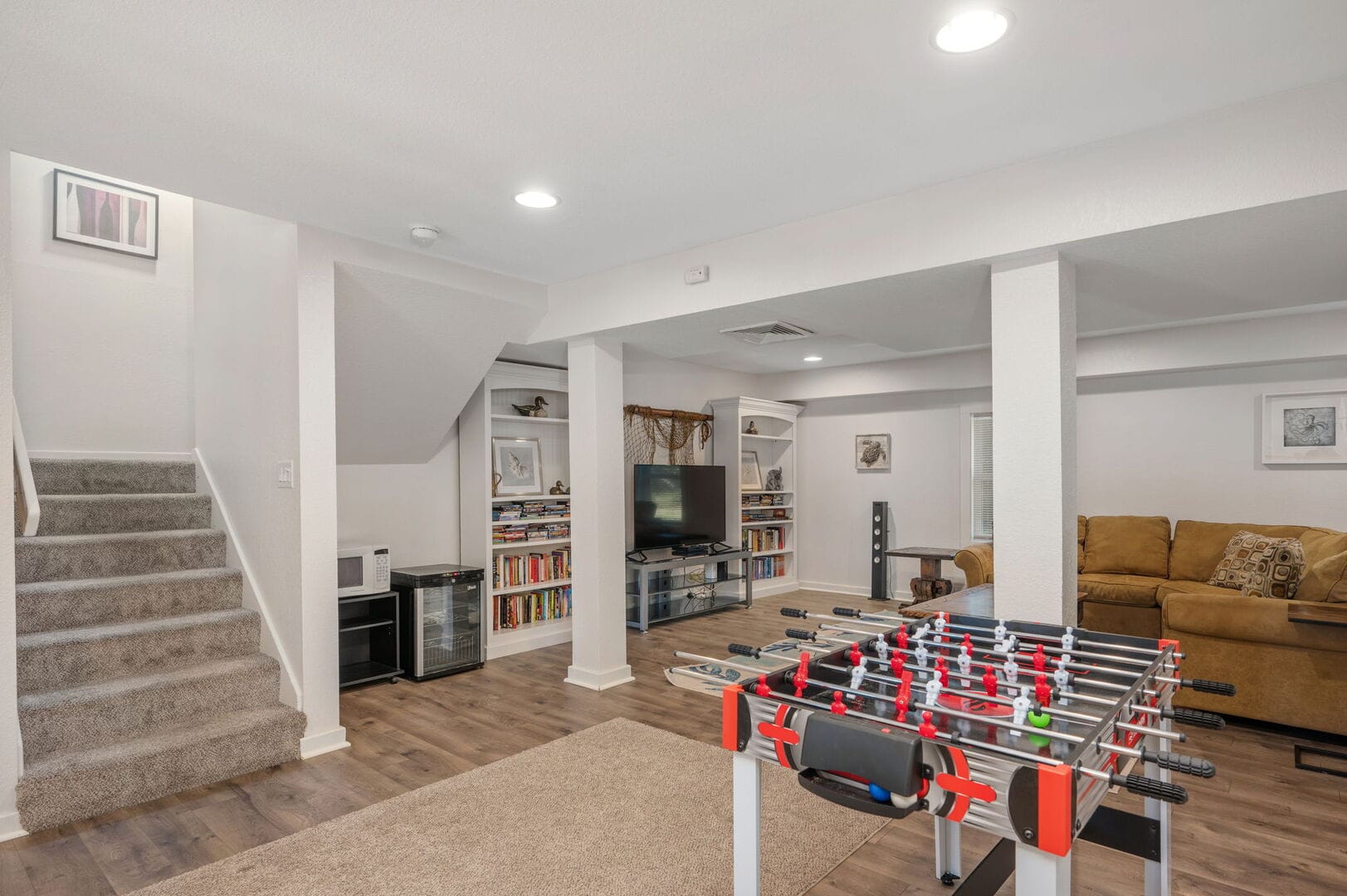 Basement with foosball and sofa.