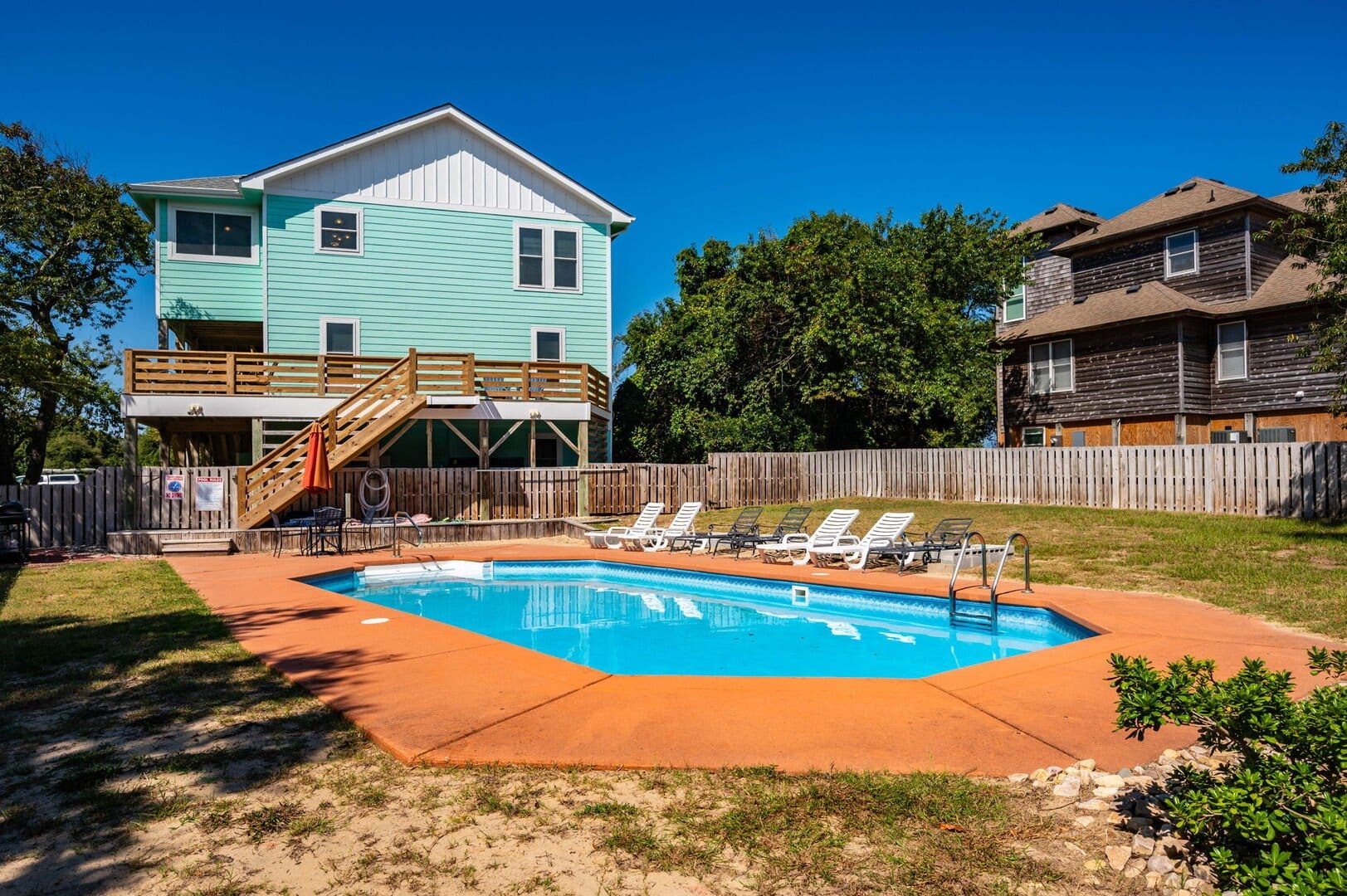 House with pool and loungers.