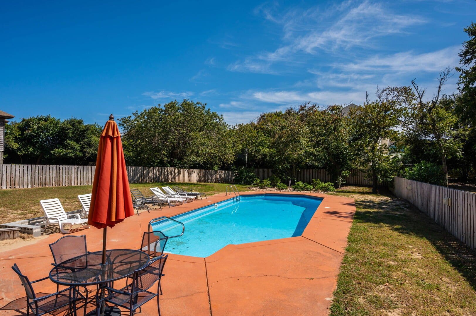 Backyard pool with seating area.