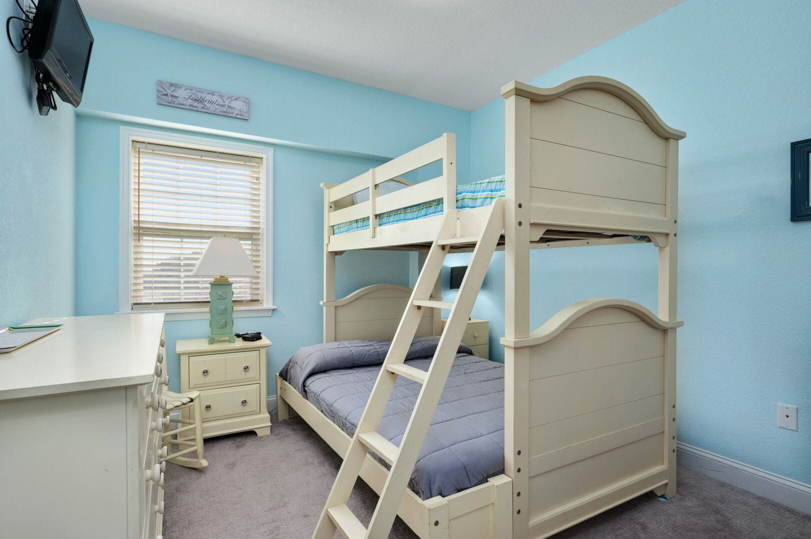 Bunk bed in blue-walled room.